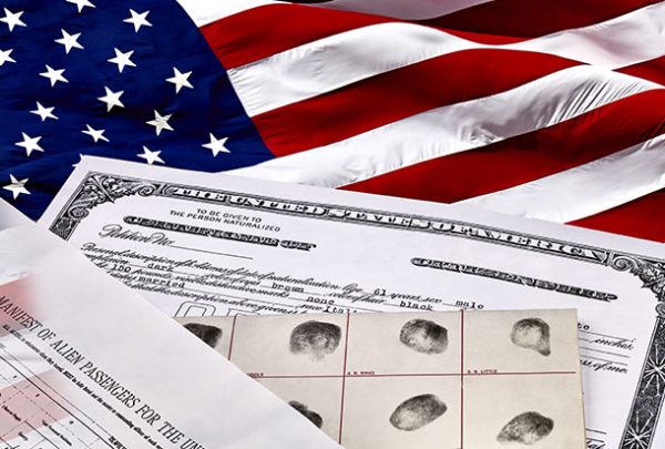 Documentos de inmigración encima de una bandera estadounidense
