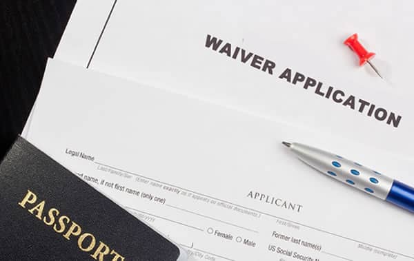 Un formulario de solicitud de exención, un bolígrafo y un pasaporte